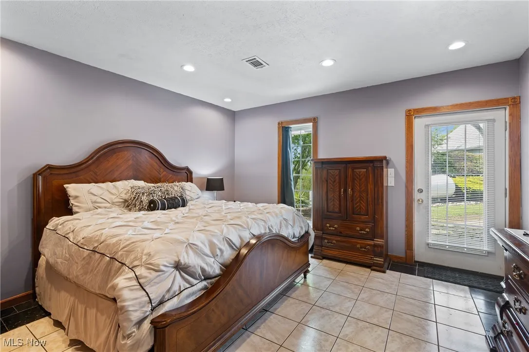 Bedroom featuring access to exterior, multiple windows, recessed lighting, baseboards, and a textured ceiling