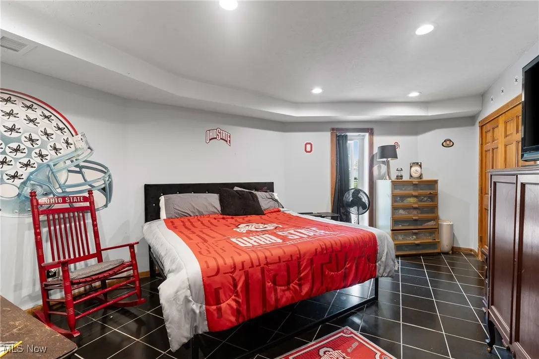 Bedroom with recessed lighting, baseboards, and dark tile patterned flooring