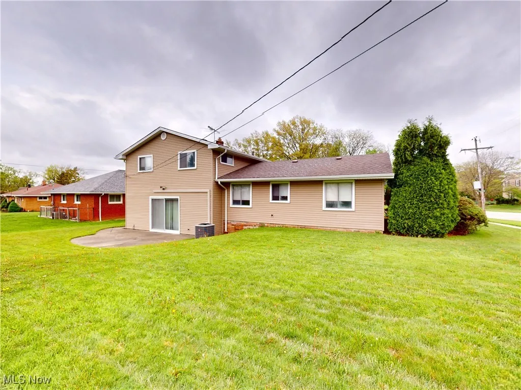 Back of house featuring a patio, a lawn, and central air condition unit