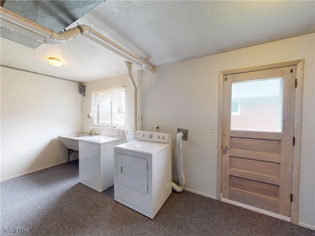 Laundry area with independent washer and dryer, carpet, and baseboards