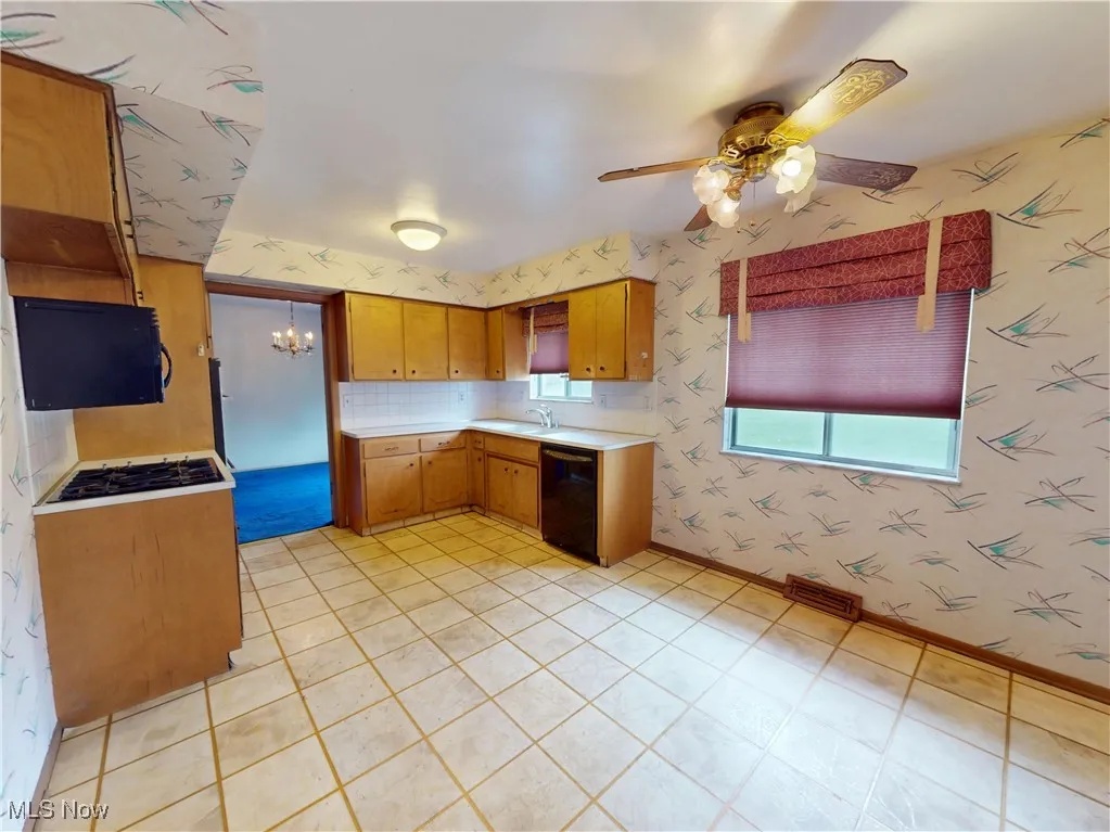 Kitchen with dishwasher, wallpapered walls, light countertops, a ceiling fan, and brown cabinets