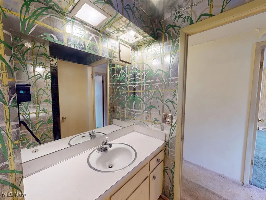 Bathroom featuring vanity and wallpapered walls