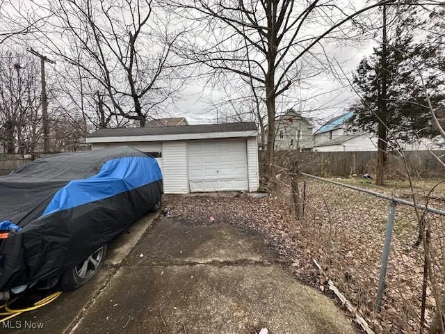 Garage with asphalt driveway and fence