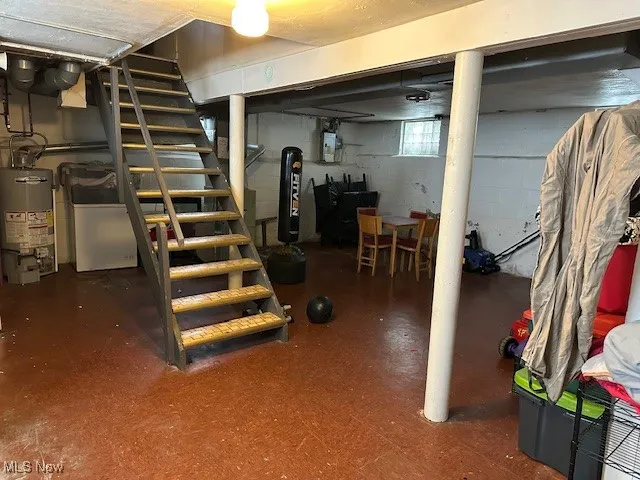 Below grade area featuring water heater and stairs