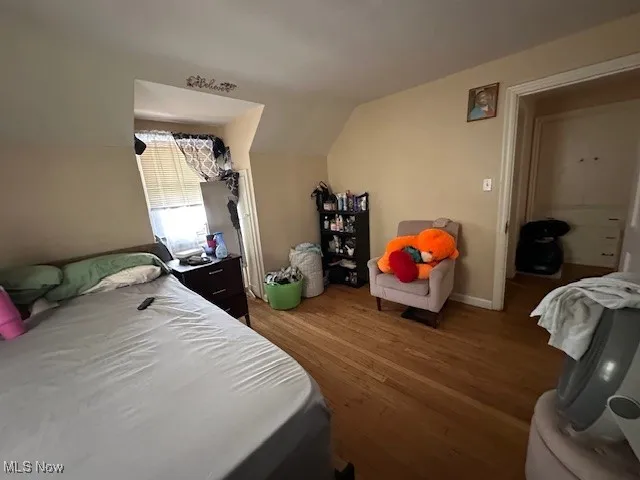 Bedroom with wood finished floors and vaulted ceiling
