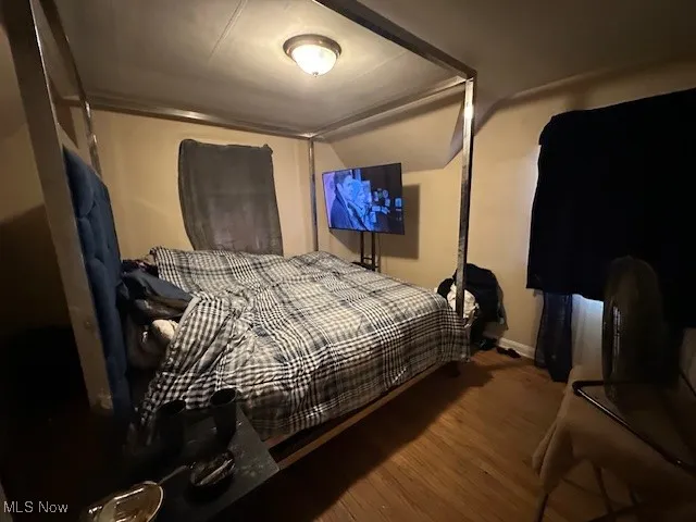 Bedroom featuring wood finished floors and lofted ceiling