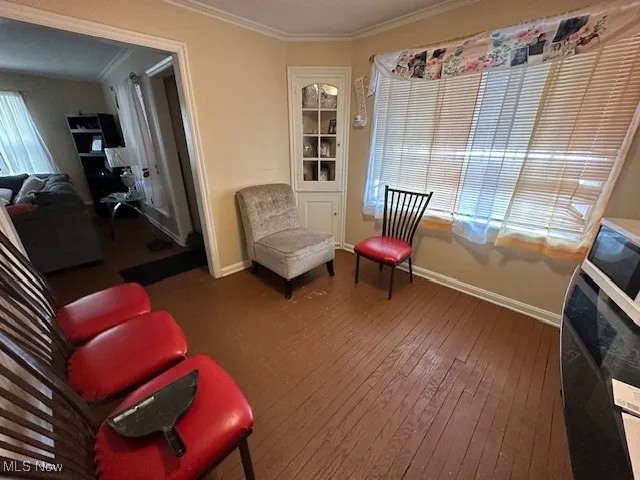 Living area with crown molding, hardwood / wood-style flooring, and baseboards