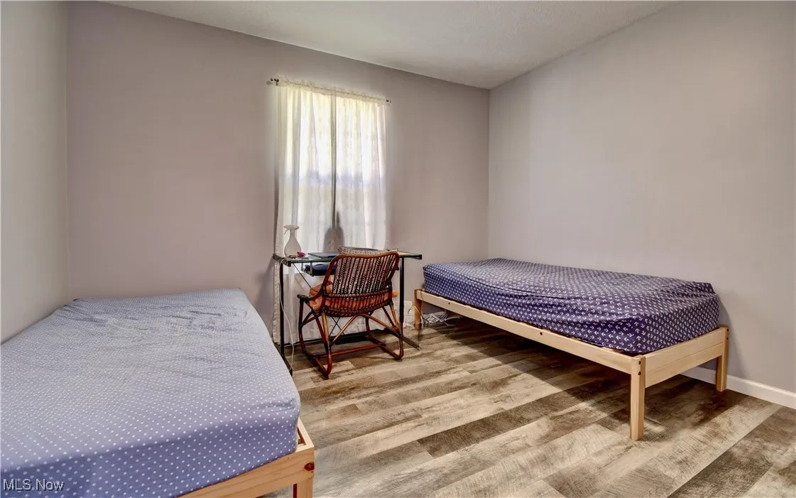 Bedroom featuring wood finished floors and baseboards