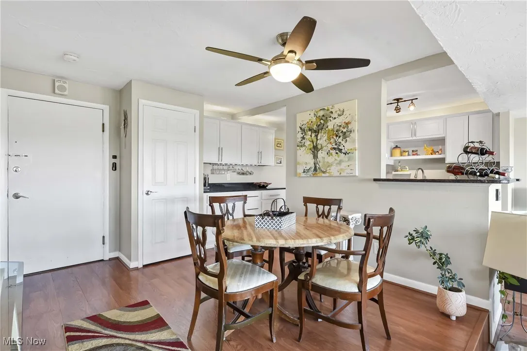 Dining space with ceiling fan, wood finished floors, and baseboards