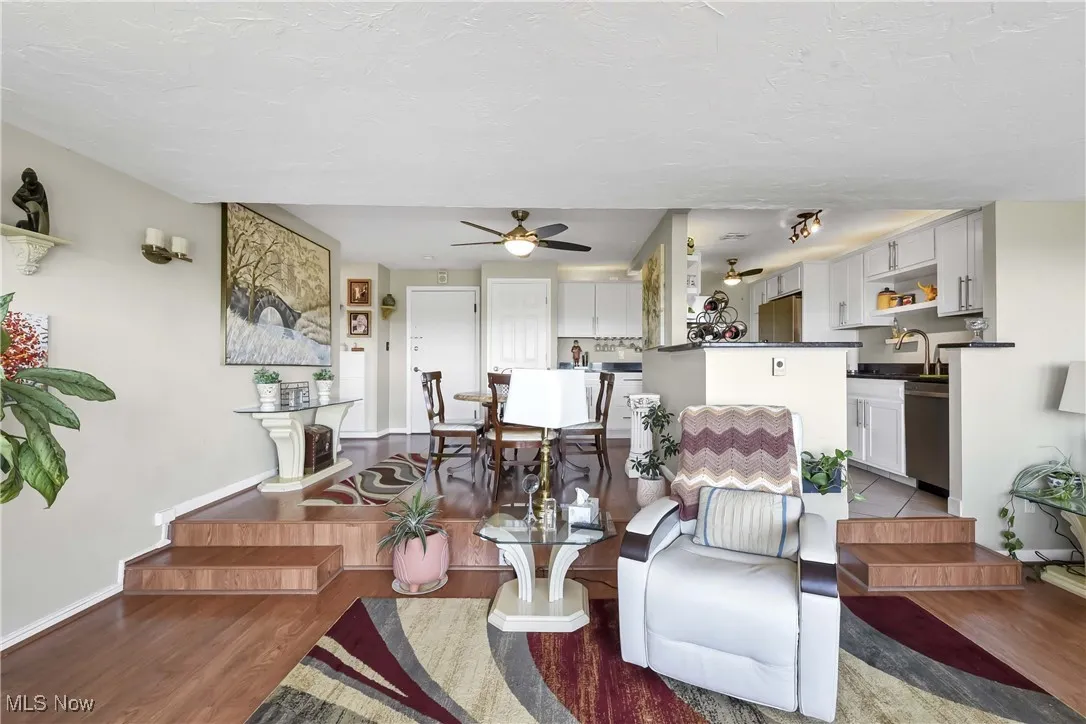 Living area with wood finished floors, ceiling fan, and baseboards