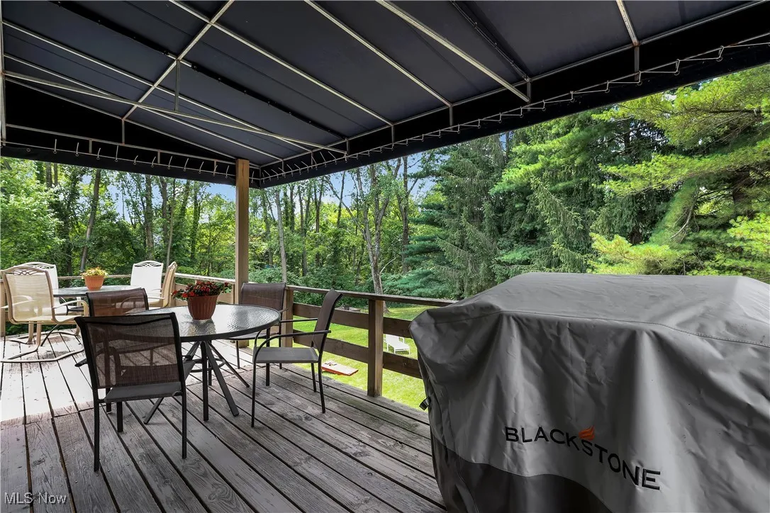 Wooden terrace featuring outdoor dining area and area for grilling
