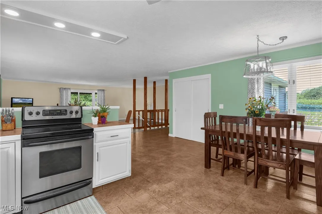 Kitchen featuring white cabinets, light countertops, recessed lighting, and stainless steel range with electric cooktop