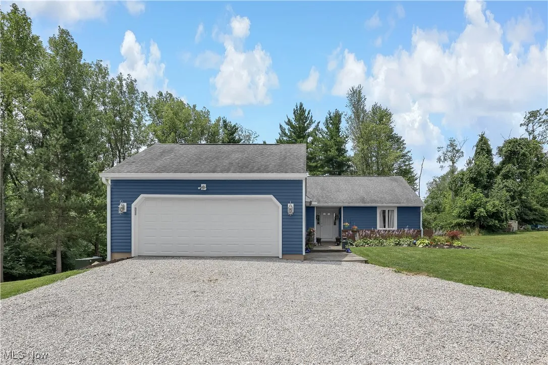 Ranch-style house with a garage, driveway, and a front lawn