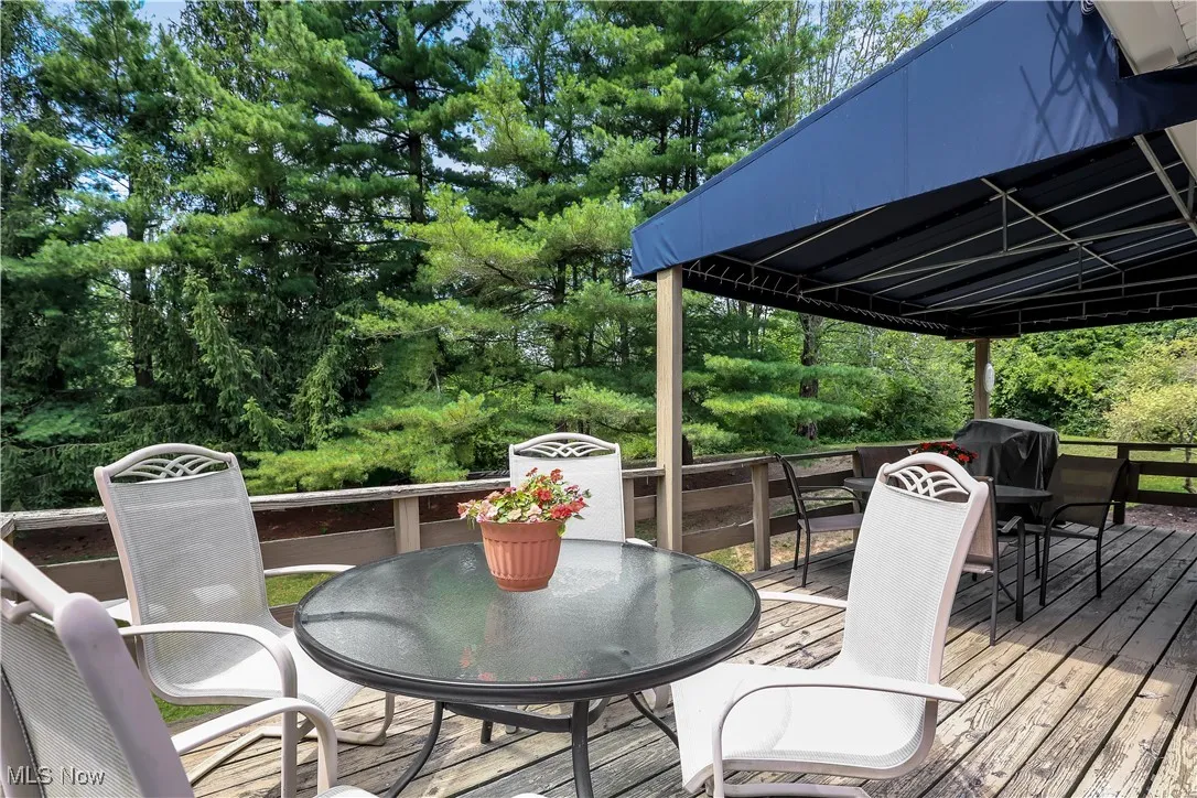 Wooden deck with outdoor dining area and a grill