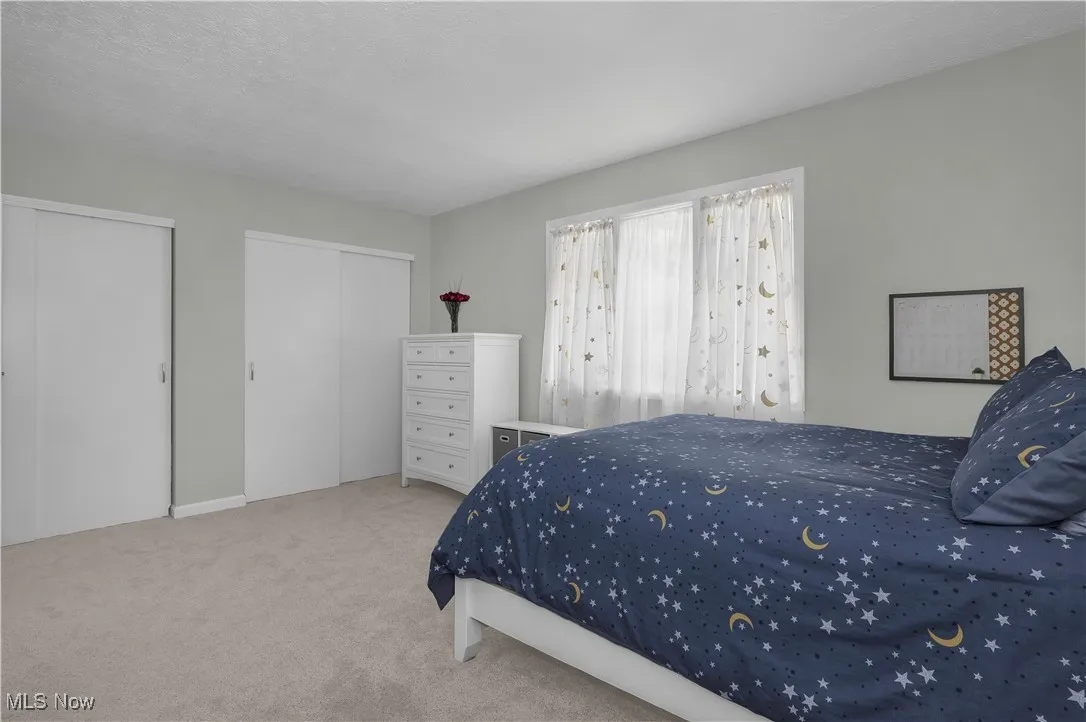 Bedroom with carpet and multiple closets
