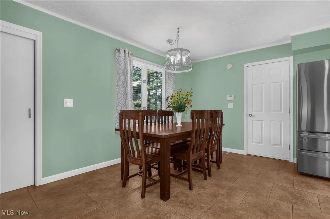 Dining area featuring an inviting chandelier, baseboards, and ornamental molding