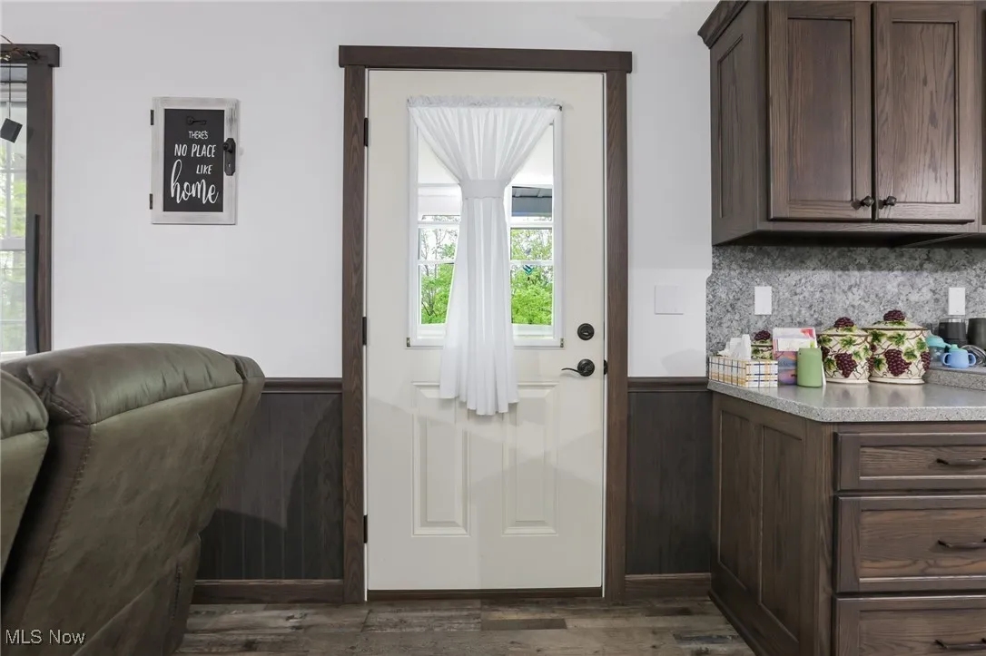 Doorway to outside with dark wood-style floors