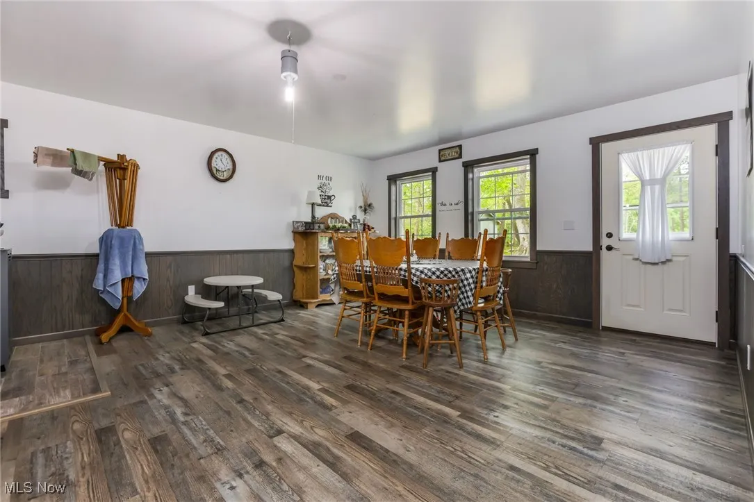 Dining area featuring a wainscoted wall, wood finished floors, and wood walls