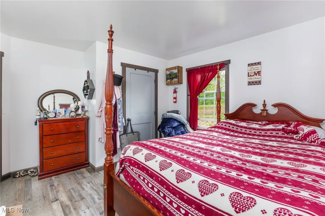 Bedroom with wood finished floors and baseboards