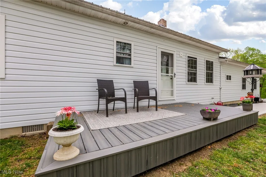 Back of house with a wooden deck and a chimney