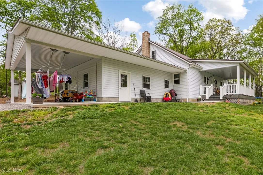 Rear view of house featuring a lawn and a chimney