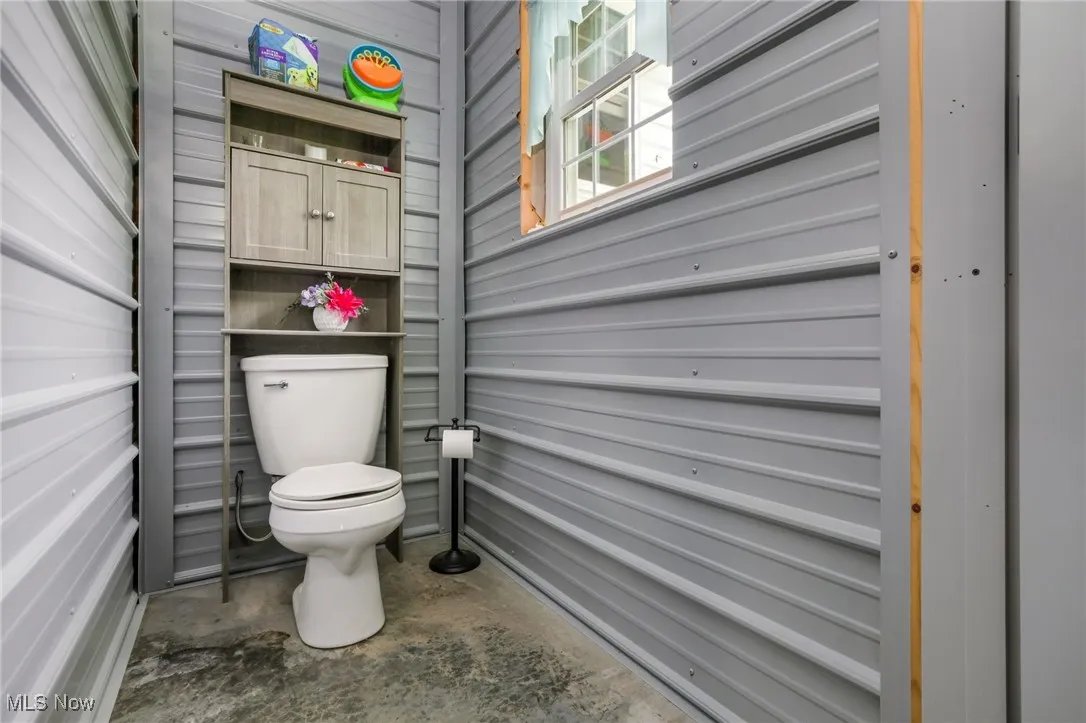 Bathroom featuring toilet and concrete floors