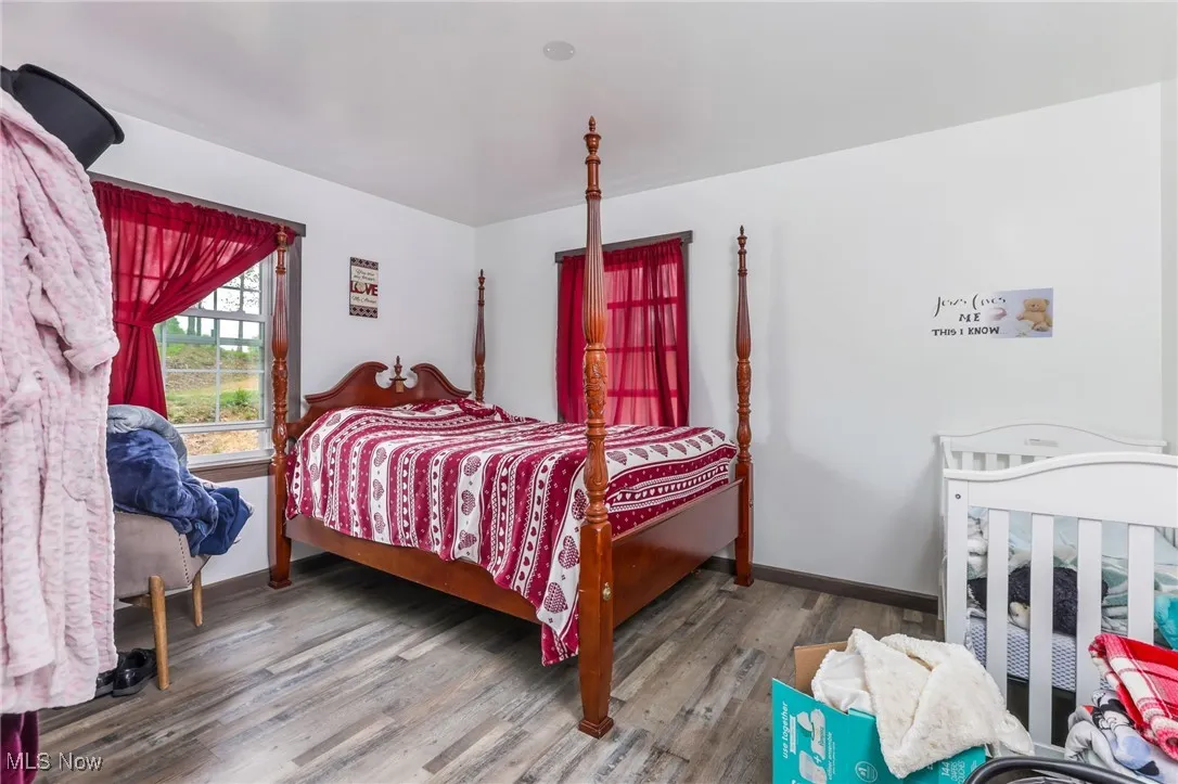 Bedroom featuring wood finished floors and baseboards