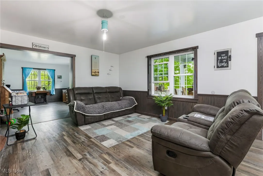 Living area featuring a wainscoted wall, wood finished floors, and wood walls
