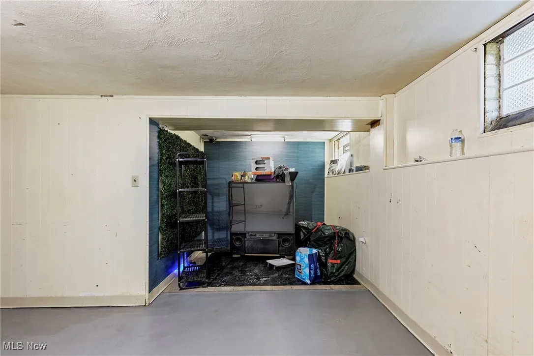 Below grade area with a textured ceiling and baseboards