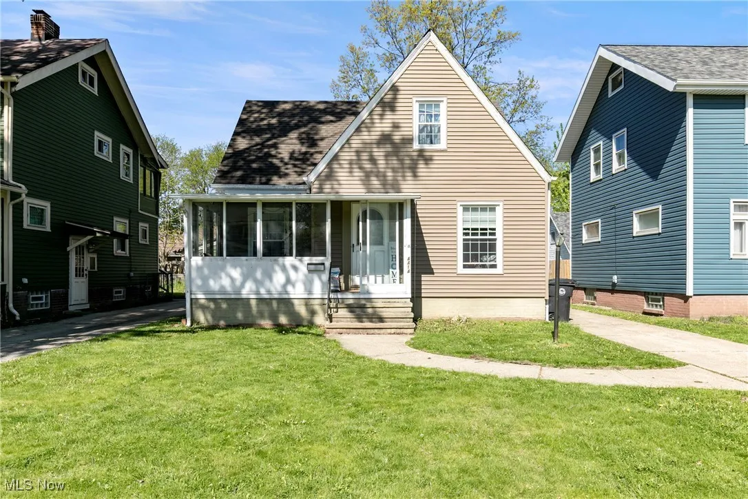 View of front facade with a front yard and a sunroom
