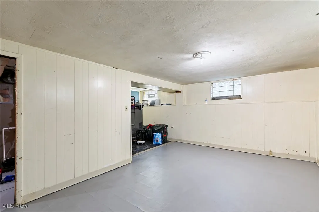 Basement featuring wooden walls and a textured ceiling