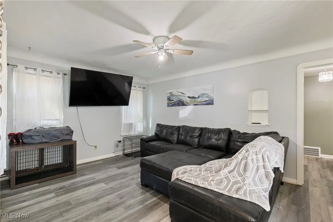 Living area featuring a ceiling fan, wood finished floors, and baseboards