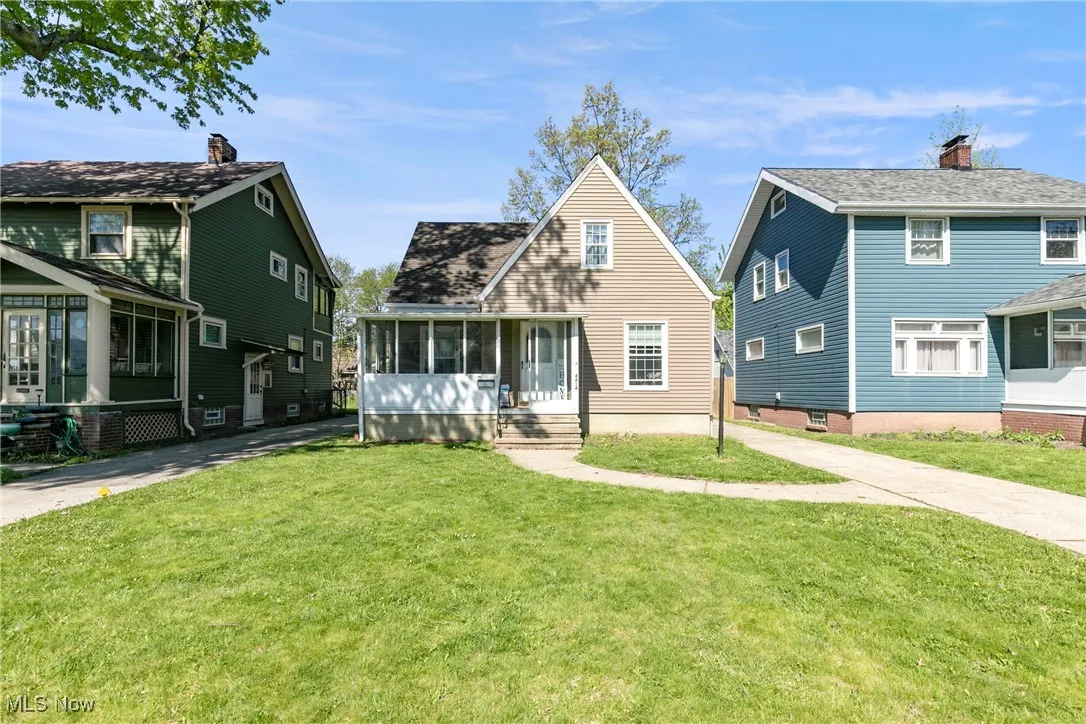 View of front of house featuring a sunroom and a front lawn