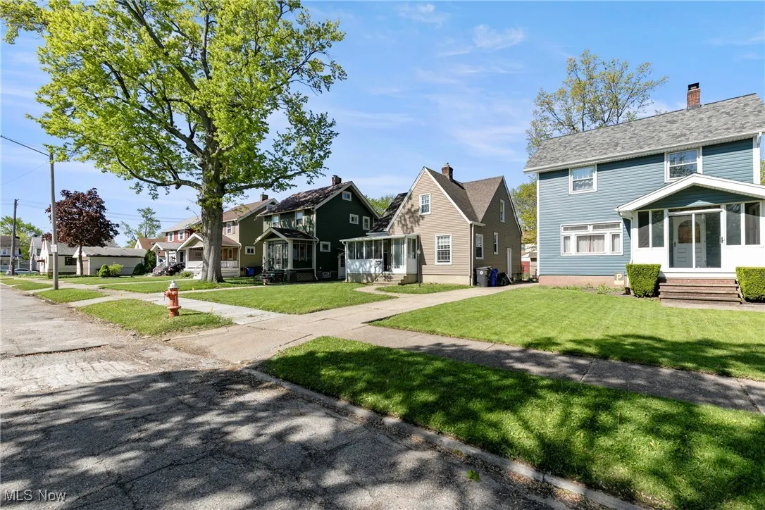 View of front of house featuring a residential view, a front lawn, entry steps, and a chimney