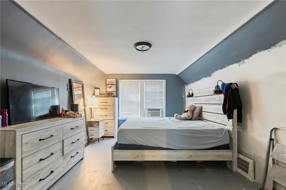 Bedroom with lofted ceiling and light wood-type flooring
