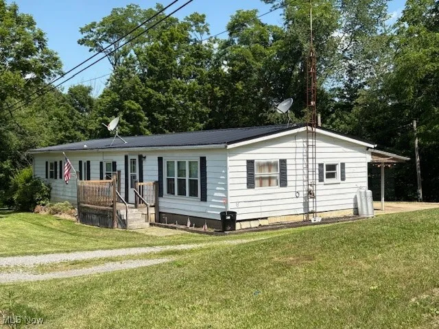 View of front facade featuring a front lawn, crawl space, and a metal roof