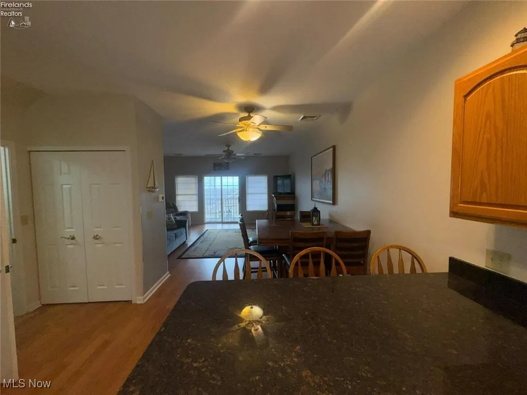 Dining space with wood finished floors and a ceiling fan