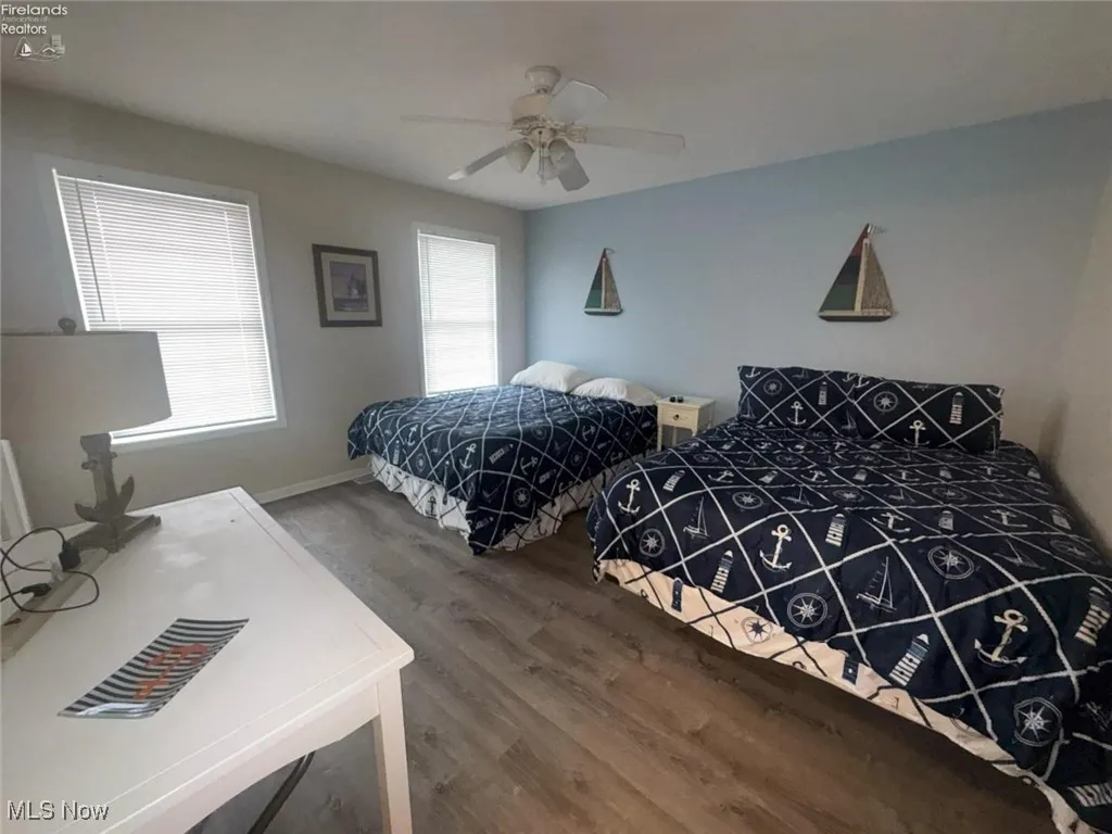 Bedroom with wood finished floors, ceiling fan, and baseboards