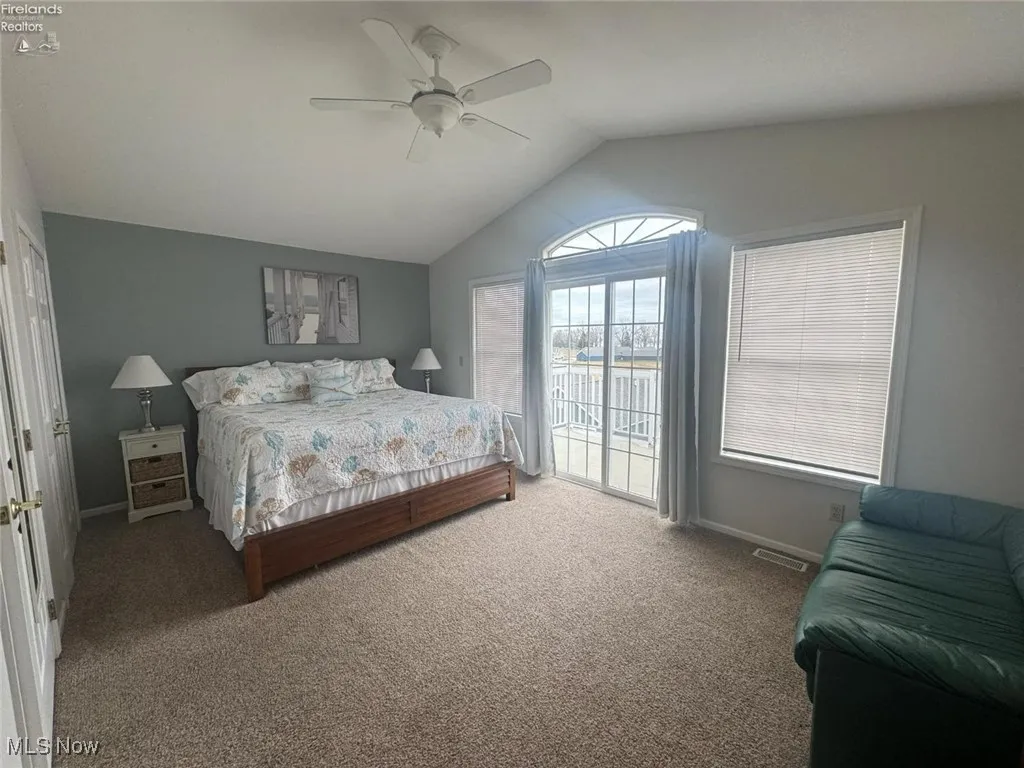 Bedroom featuring access to outside, lofted ceiling, carpet, ceiling fan, and baseboards