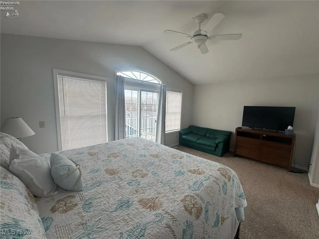 Bedroom with carpet floors, vaulted ceiling, and ceiling fan