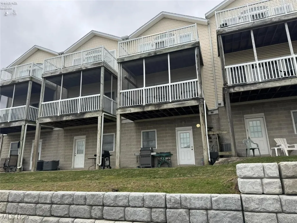 Rear view of house with a lawn and a balcony