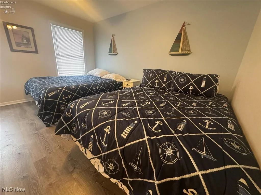 Bedroom with wood finished floors and baseboards
