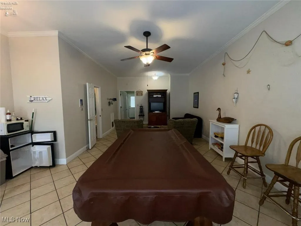 Game room featuring billiards table, light tile patterned flooring, ornamental molding, a ceiling fan, and baseboards