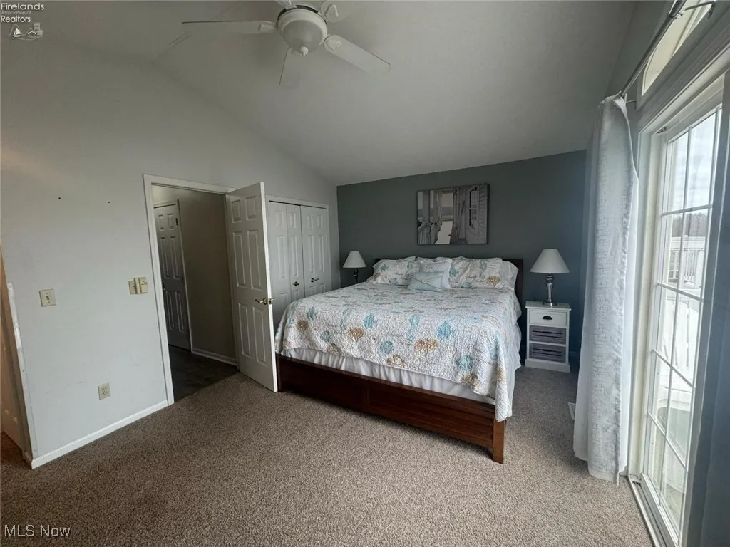 Bedroom featuring carpet flooring, lofted ceiling, baseboards, a closet, and a ceiling fan
