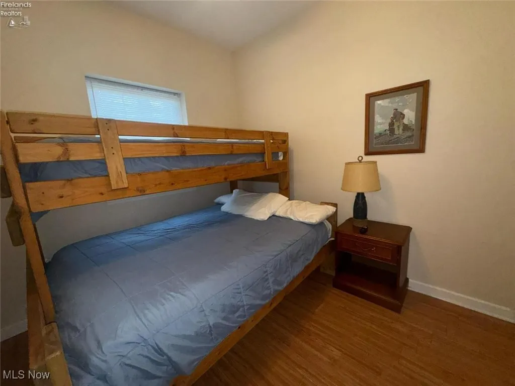 Bedroom with wood finished floors and baseboards