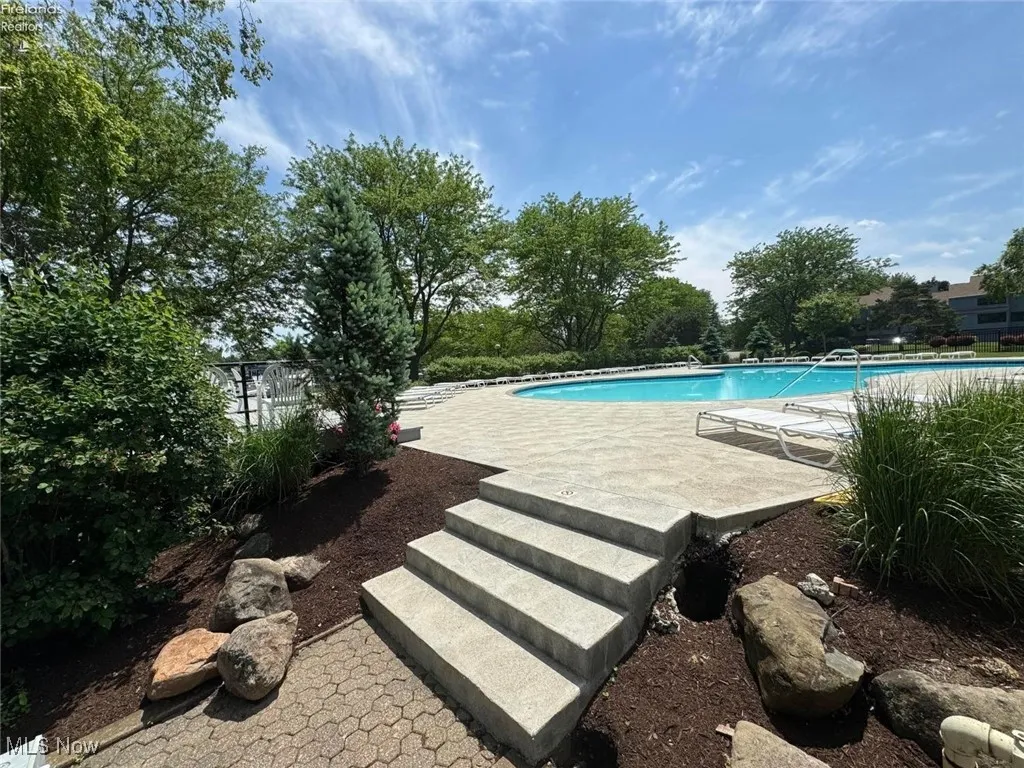 Community pool with fence and a patio area