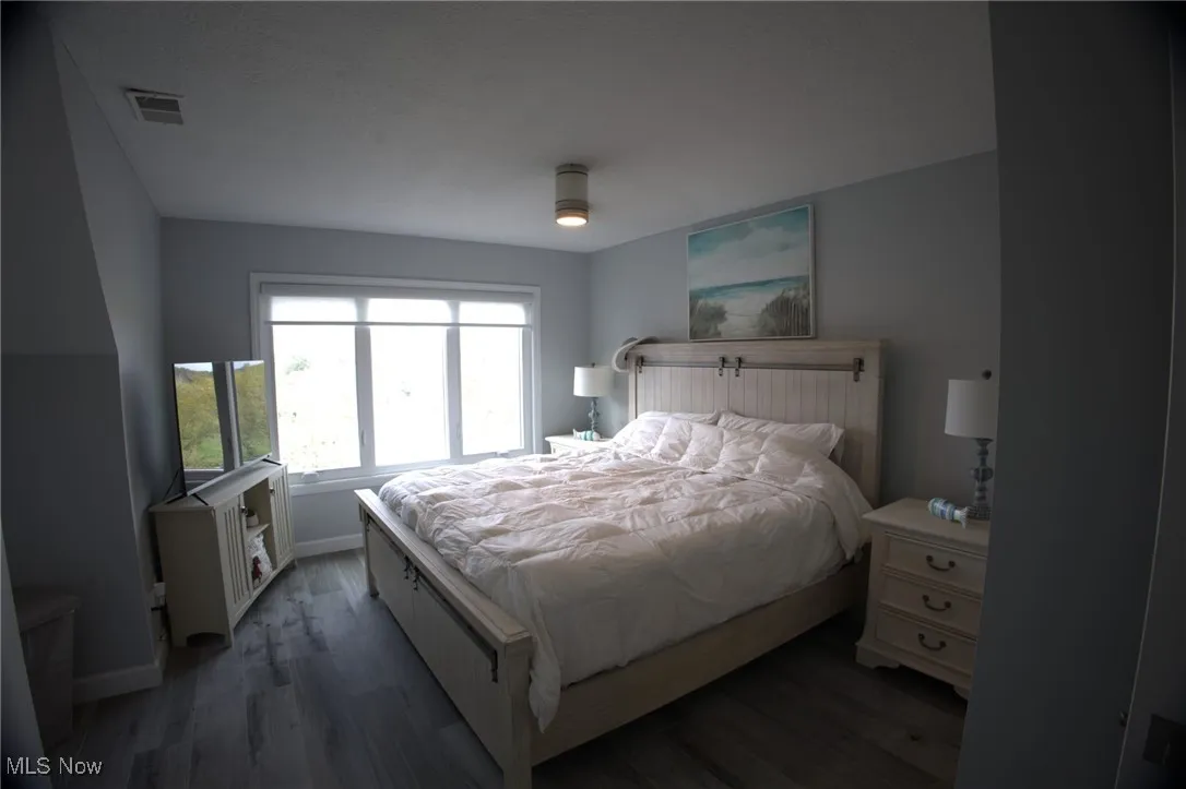 Bedroom with wood finished floors, baseboards, and ceiling fan