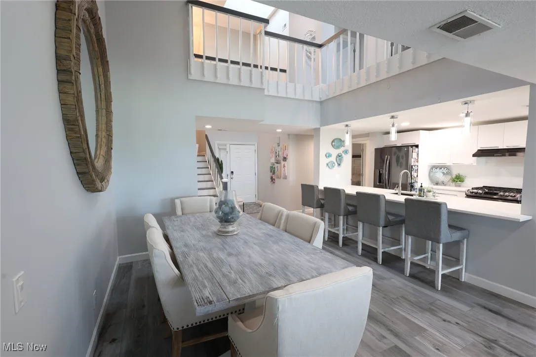 Dining room featuring baseboards, light wood-style flooring, and stairway