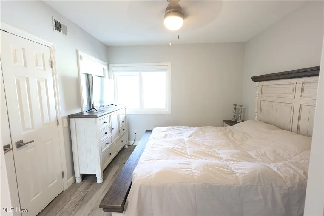 Bedroom with light wood finished floors and a ceiling fan