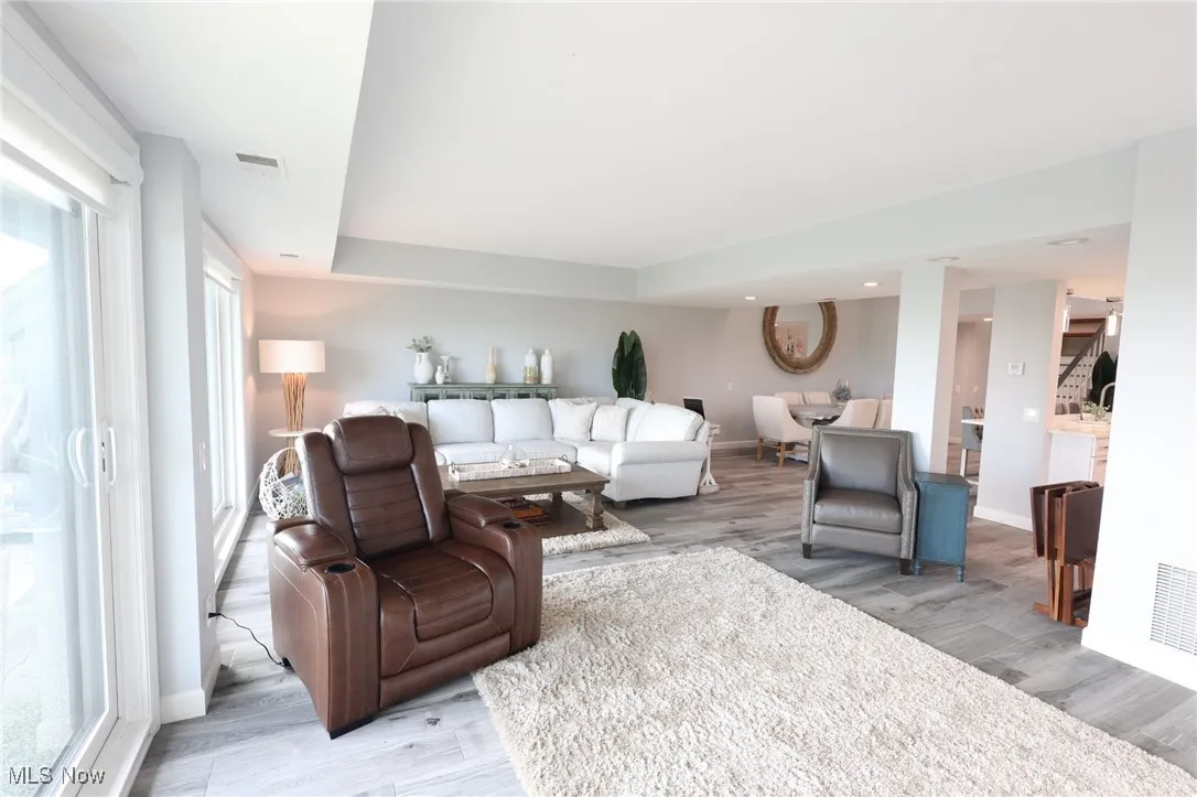 Living room featuring light wood finished floors, plenty of natural light, and baseboards